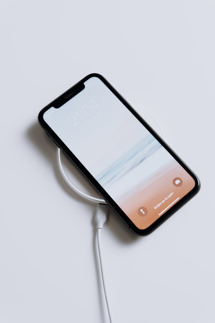 A sleek smartphone charging wirelessly, showcasing minimalist design and modern technology.